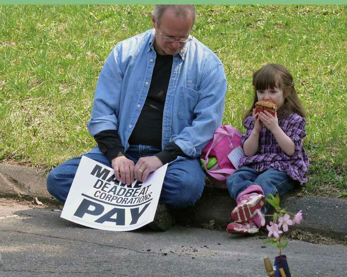 Trumbull resident Ruben Berkowitz and his three-year-old daughter Veronica Rose attend a rally Monday to protest tax breaks given to corporations like General Electric.