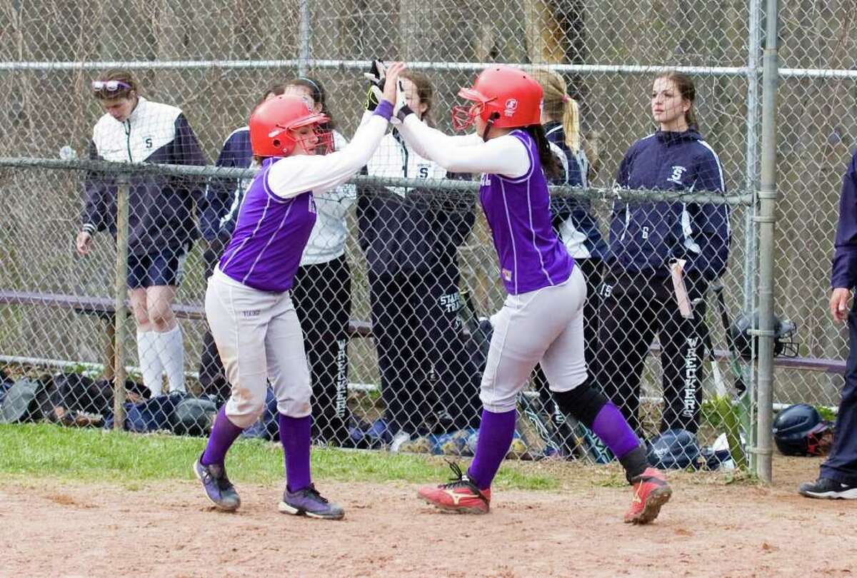 Westhill's Allie Souza, left, and Britt Horn celebrate their game winning runs after crossing the plate as Westhill High School hosts Staples in a softball game in Stamford, Conn., April 18, 2011.
