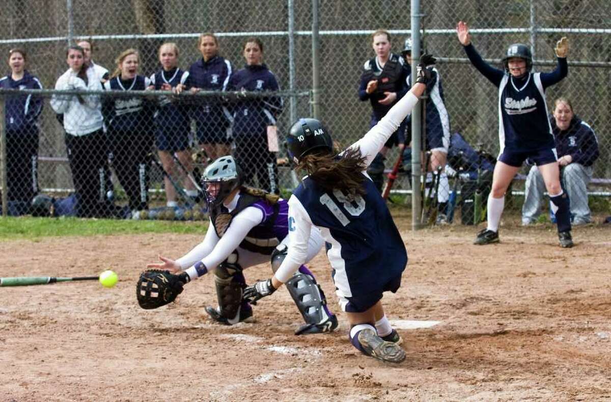 Staples' Alex Masiello slides into home safely as Westhill catcher Liz Joseph waits for the ball as Westhill High School hosts Staples in a softball game in Stamford, Conn., April 18, 2011.
