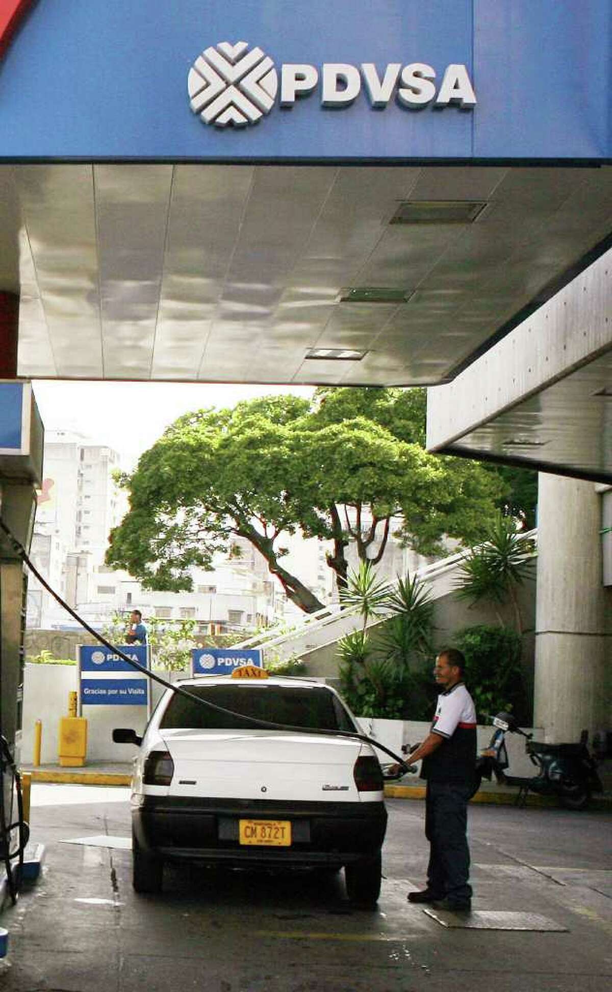 A gas attendant fills the tanks a car at a Petroleos de Venezuela S.A. station in Caracas, Venezuela, in this file photo. U.S. prosecutors say Francisco Illarramendi, a Venezuelan-American residing in New Canaan, used unregistered hedge funds in Stamford as cover for a massive Ponzi scheme with exclusively overseas clients, including the pension funds for workers at the government-run oil company. Photographer: Susana Gonzalez/Bloomberg News