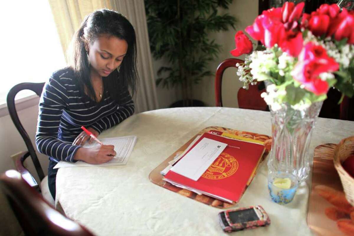 Meseret "Missy" Alemu fills out paperwork for financial help to attend college at her home on Wednesday, April 6, 2011. The first in her family to attend college, she will graduate from high school as valedictorian.