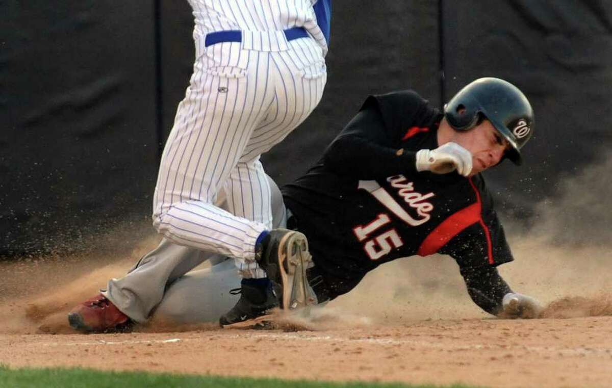 Fairfield Warde's #15 Will Halliday slides into home plate to score a run, during boys baseball action against Fairfield Ludlowe at the Ballpark at Harbor Yard in Bridgeport, Conn. on Thursday April 21, 2011. Looking to make the tag is Ludlowe's pitcher #6 Victor D'Ascenzo.