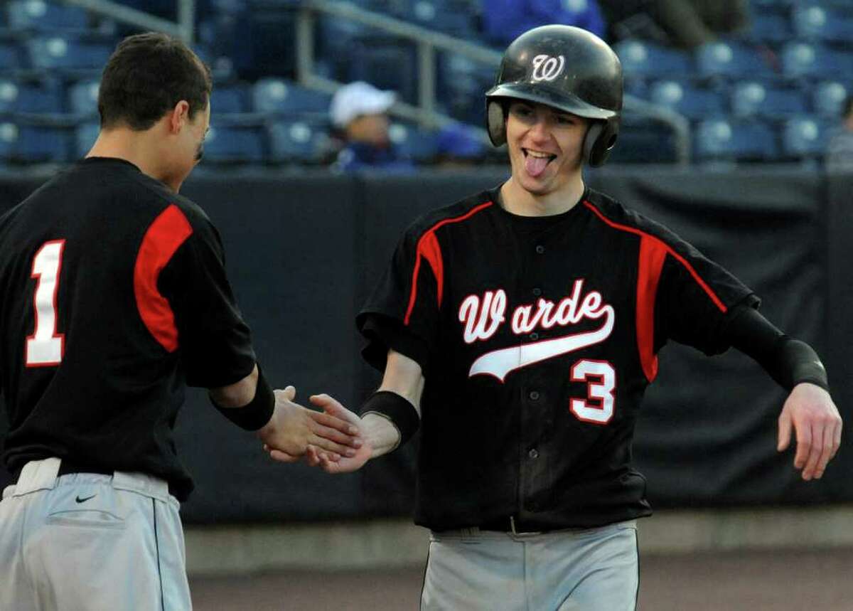 Fairfield Warde's #3 Carl Steccato, right, reacts after scoring a run, during boys baseball action against Fairfield Ludlowe at the Ballpark at Harbor Yard in Bridgeport, Conn. on Thursday April 21, 2011. At left is teammate #1 Michael Garcia.