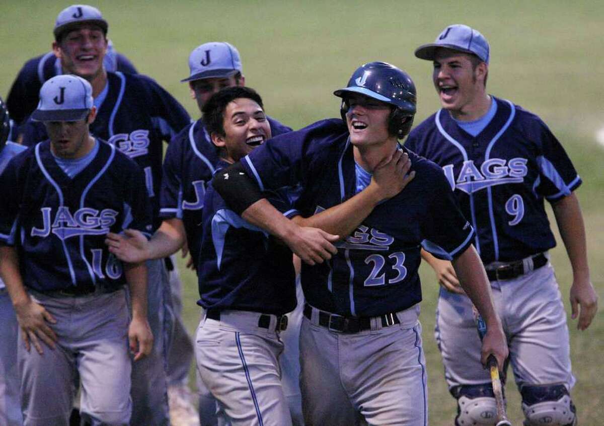 FOR SPORTS - Johnson's Klaus Bohrmann (center right) celebrates with teammate Marcus Cardoza after scoring against Reagan in the second inning Thursday April 21, 2011 at Blossom baseball field. (PHOTO BY EDWARD A. ORNELAS/eaornelas@express-news.net)