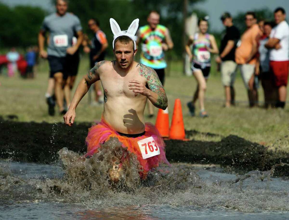 Brian Bowman wears a humorous costume as he enters a muddy water hole.