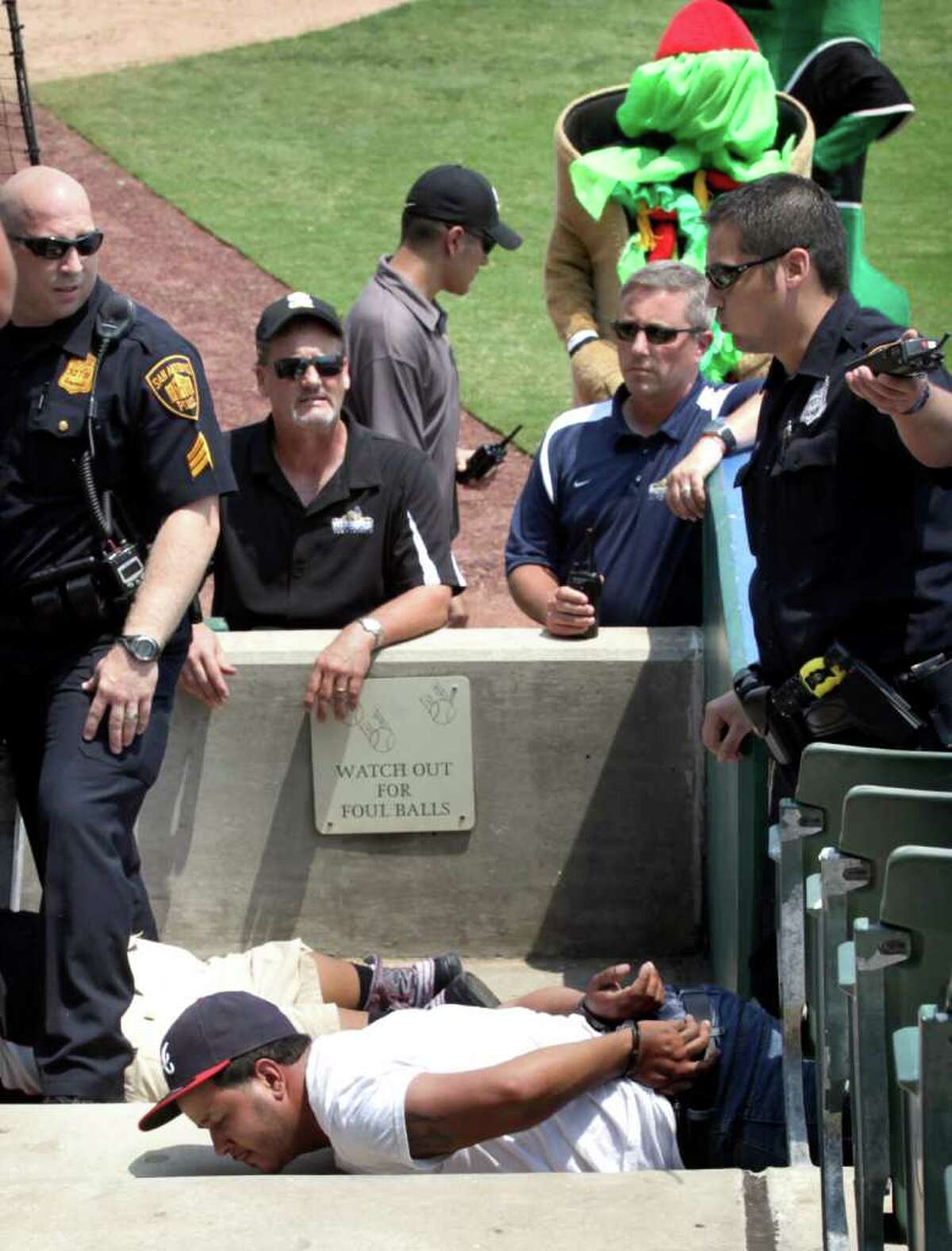 Sports daily - San Antonio police officers detain two San Antonio Missions fans after a altercation between them and members of the Frisco RoughRiders at Wolff Stadium, Tuesday, April 26, 2011. RoughRiders team members threw a bat and a trash can at the fans at the end of the game after the umpire called back a homerun call by the RoughRiders. Photo Bob Owen/rowen@express-news.net