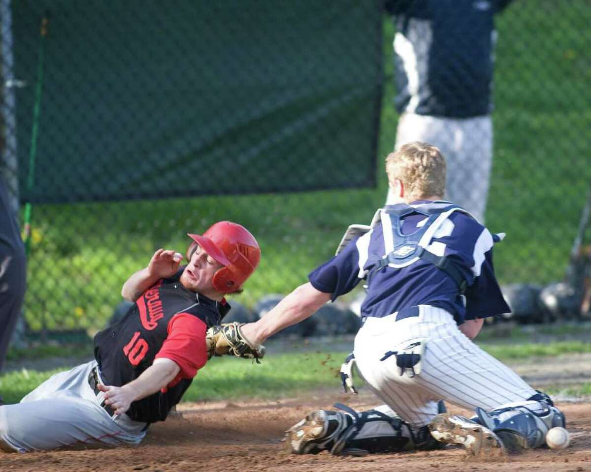Pomperaug's Brent Pelella slides home safely as Immaculate catcher Matt Harrison is unable to catch the throw to the plate Tuesday at Immaculate High School.
