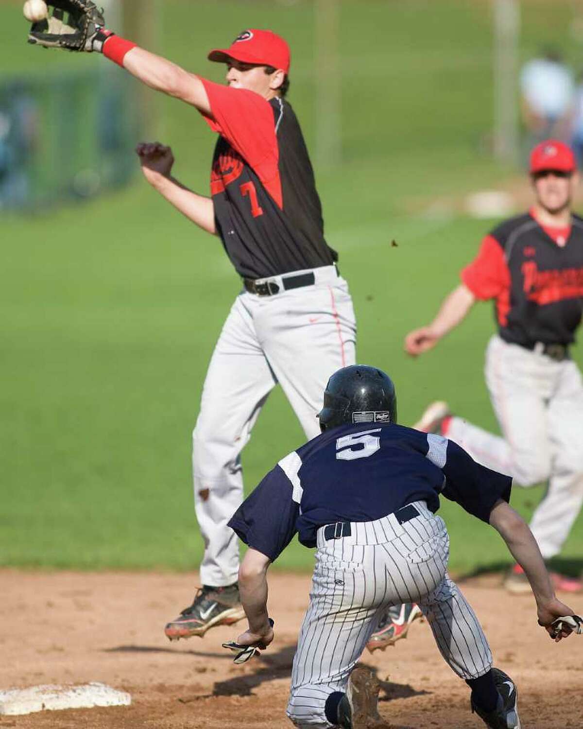 Pomperaug second baseman Garrett DeLotto gloves a high throw and still got the tag down in time to catch Immaculate's Brad Mannion stealing Tuesday at Immaculate High School.