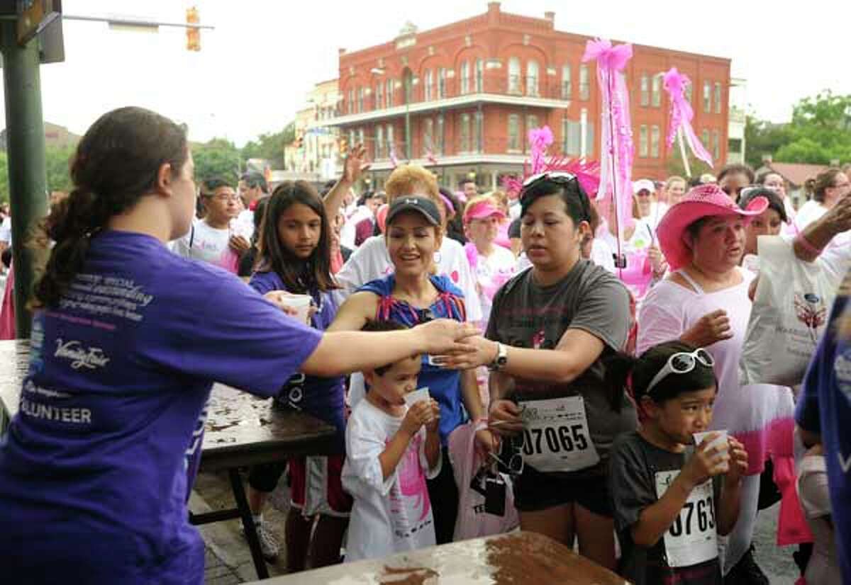 Reagan High School Spanish Club members pass out refreshments to participants in the Susan G. Komen Race for the Cure in downtown San Antonio on Saturday, April 30, 2011. BILLY CALZADA / gcalzada@express-news.net