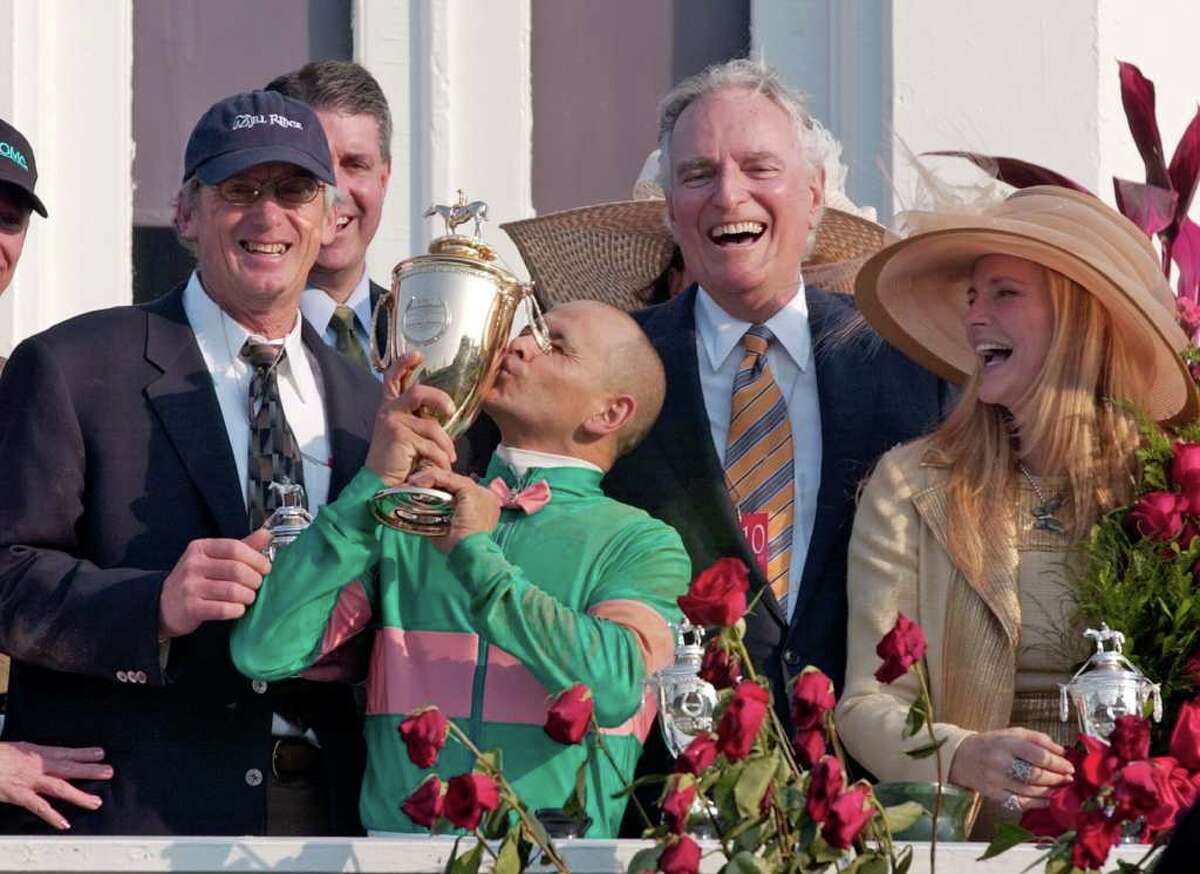 Jockey Mike Smith kisses the trophy as trainer John Shirreffs, left, and owners Jerome and Ann Moss look on after Smith rode Giacomo to win the Kentucky Derby at Churchill Downs, Saturday, May 7, 2005, in Louisville, Ky. (AP Photo/Ed Reinke)