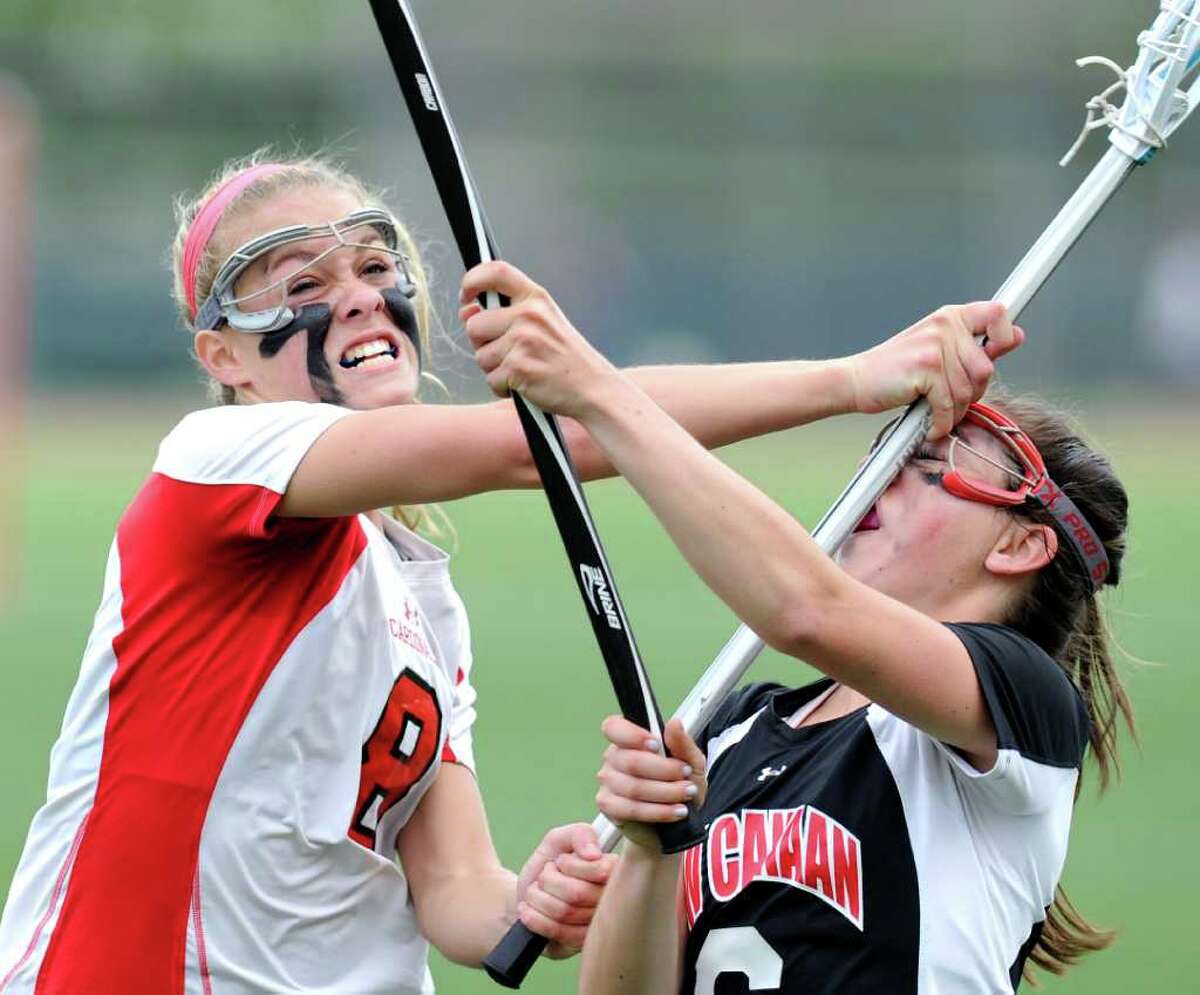While going to break up a pass, Tori Dunster, left, # 8 of Greenwich High School, puts her stick into the face of Bea Eppler, right, # 6 of New Canaan High School, during girls high school lacrosse game between Greenwich High School and New Canaan High School at Greenwich High School, Tuesday afternoon, May 3, 2011. New Canaan won the match 14-9.