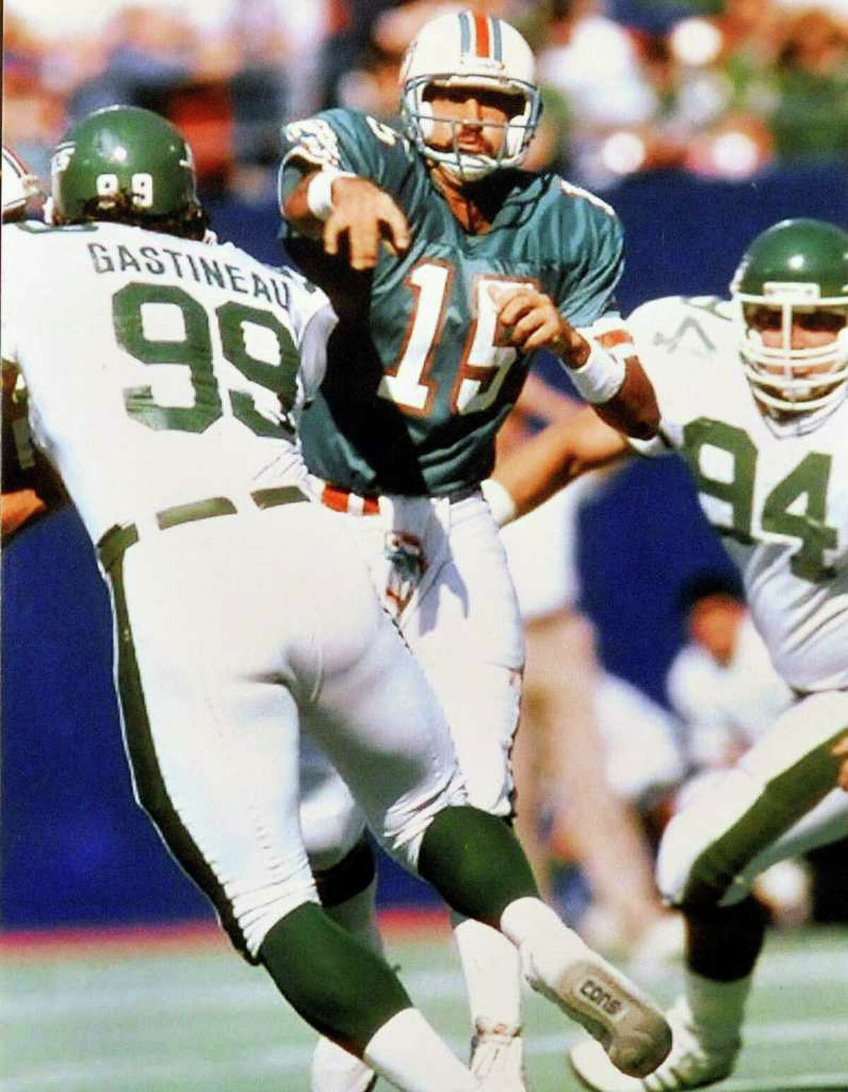 Miami Dolphin quarterback Kyle Mackey throws against the rush by NY Jets defensive end Mark Gastineau during the 1987 season. Mackey is a former National Football League player who played for the Miami Dolphins during the 1987 players strike and later played for the New York Jets. Tuesday, April 26, 2011. Valentino Mauricio/The Enterprise