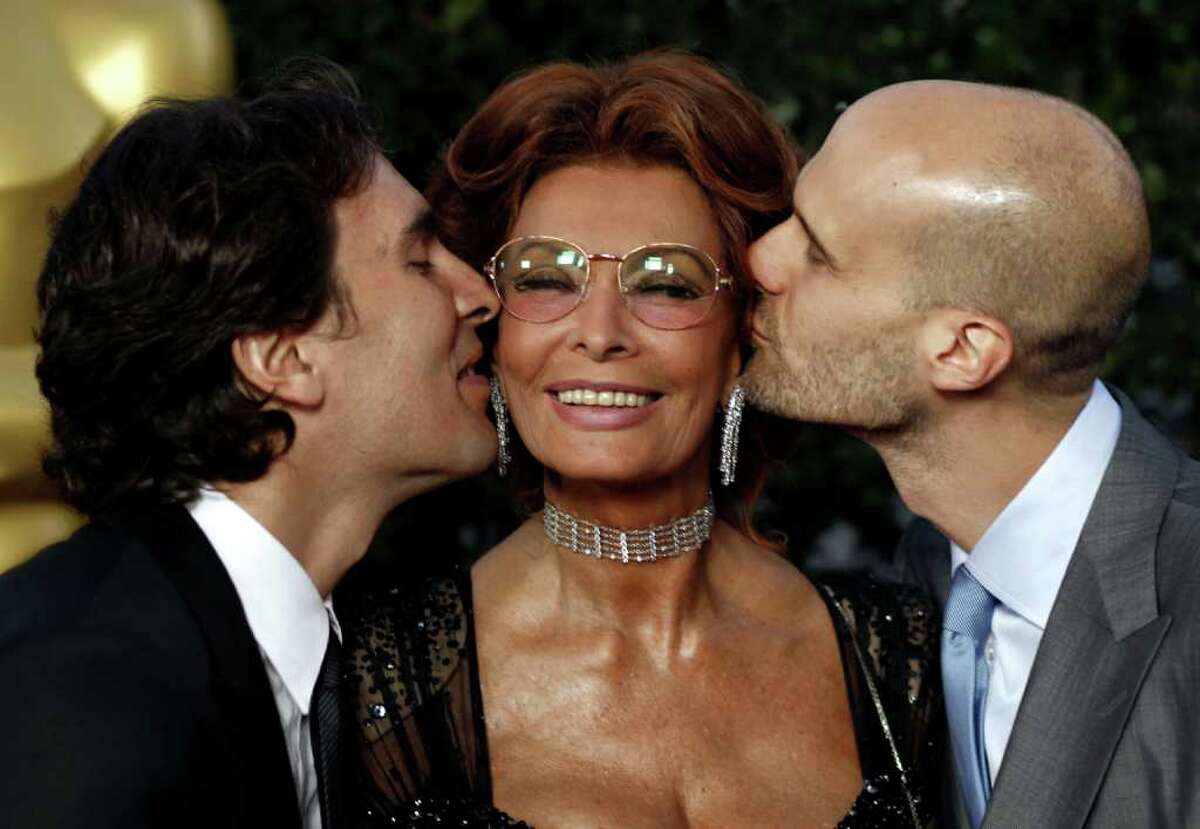 Actress Sophia Loren, center, gets a kiss from her sons, Carlo Ponti Jr., left, and Edoardo Ponti at The Academy of Motion Picture Arts and Sciences Tribute honoring her in Beverly Hills, Calif., Wednesday, May 4, 2011. Loren's life and career will be celebrated by friends and colleagues Wednesday.