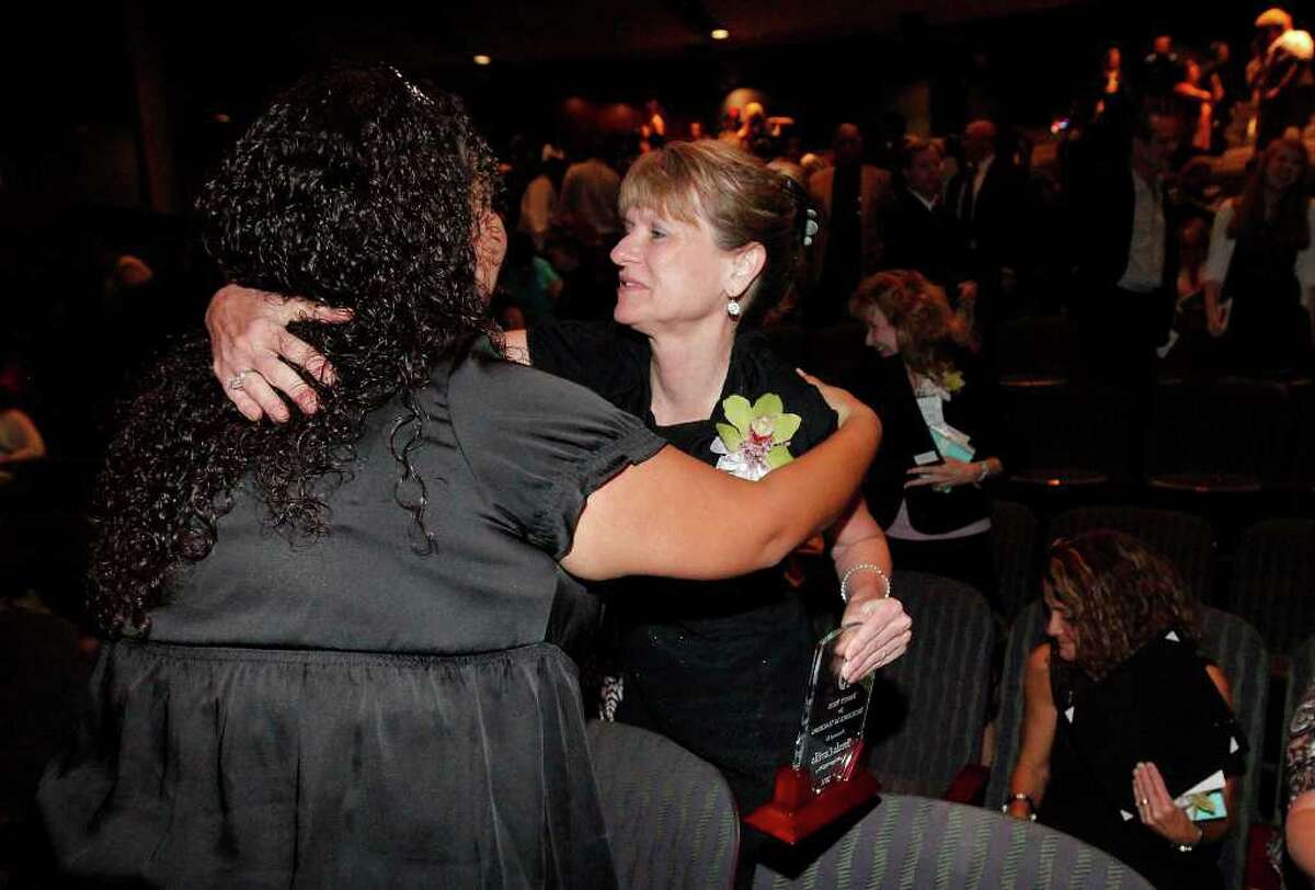 Brenda Carrillo (center) receives a hug from Leslie Ann Garza after Carrillo was awarded the Trinity Prize for Excellence in Teaching at Trinity University on Friday, May 6, 2011. Carrillo was joined by 19 area educator finalists and only one of two to receive the $2,500 prize and recognition for her work in the classroom. Carrillo has been an educator for 28 years and teaches biology at McCollum High School of which she is also an alumni. Kin Man Hui/kmhui@express-news.net