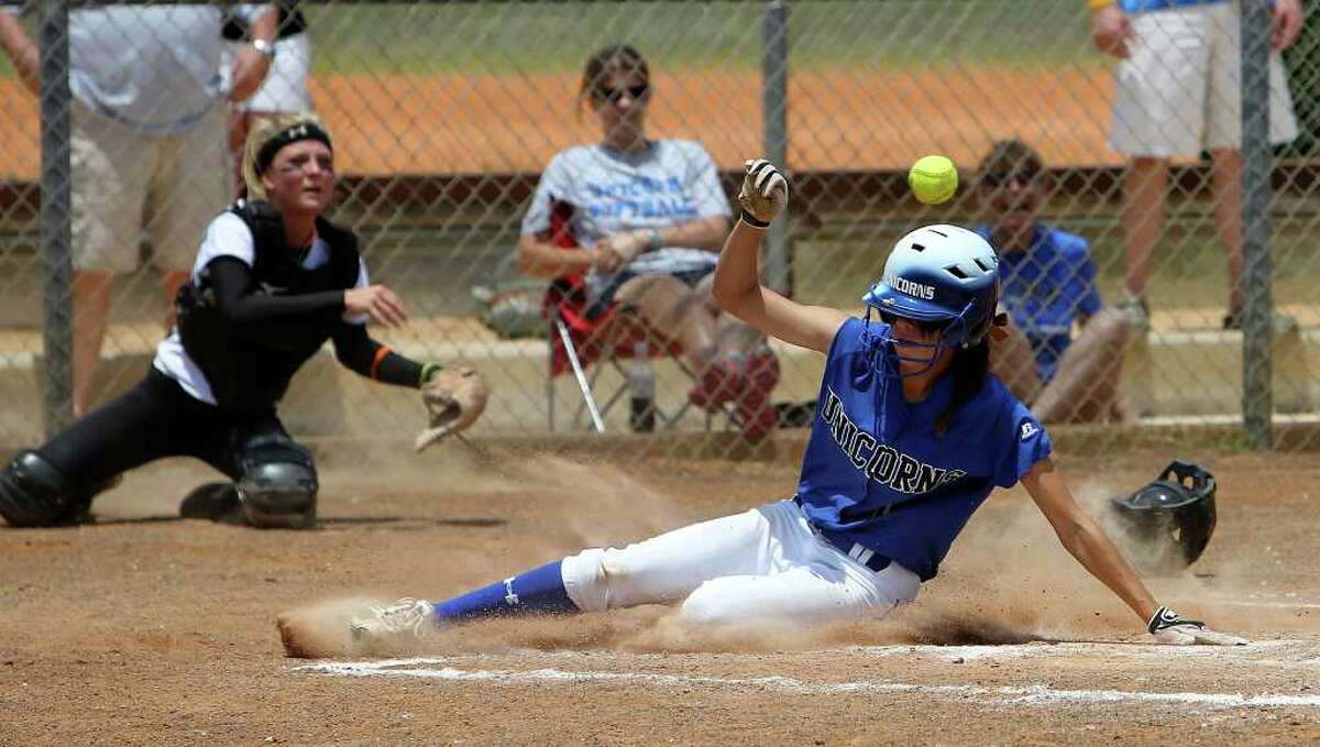 New Braunfels' Jade Smith beats the throw to home plate by East Central catcher Brittany Covert (left) to score a run in the fifth inning in softball at East Central on Saturday, May 7, 2011. New Braunfels clinched a playoff victory winning 6-2 in game 2. Kin Man Hui/kmhui@express-news.net