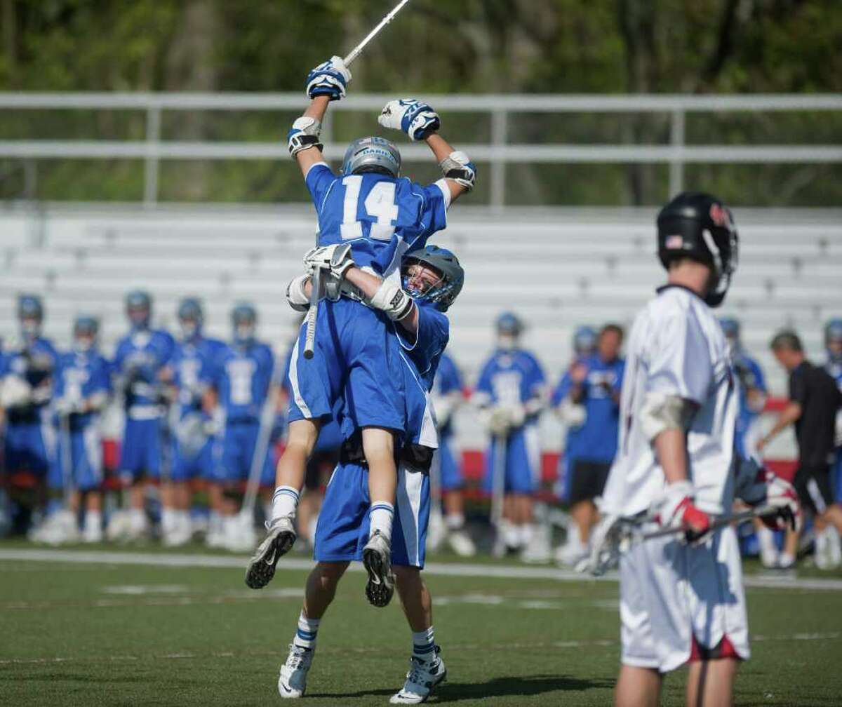 Darien High School's Scotty Waters (14) is congratulated by teammate Baylis Treen after scoring against New Canaan in boys lacrosse in New Canaan, Conn. on Saturday May 7, 2011.