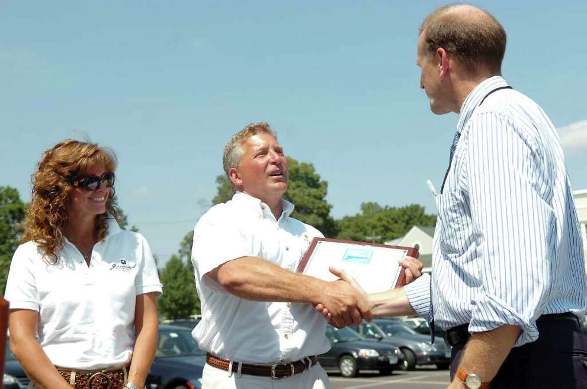 In this Aug. 19, 2009, file photo, director of the state Department of Environmental Protection's Long Island Sound Program, Brian Thompson, right, presents Beacon Point Marine owner Rick Kral and his wife Cindy with an award recognizing the Cos Cob marina as the state's 15th Clean Marina.