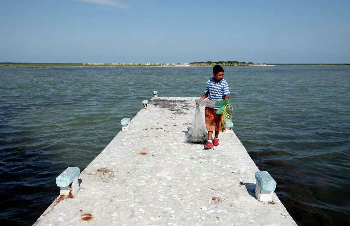 A boy gathers his cast net in Carbonera, Mexico. For a time, terrified village residents didn't leave their homes at night. PHOTO BY EDWARD A. ORNELAS/eaornelas@express-news.net)