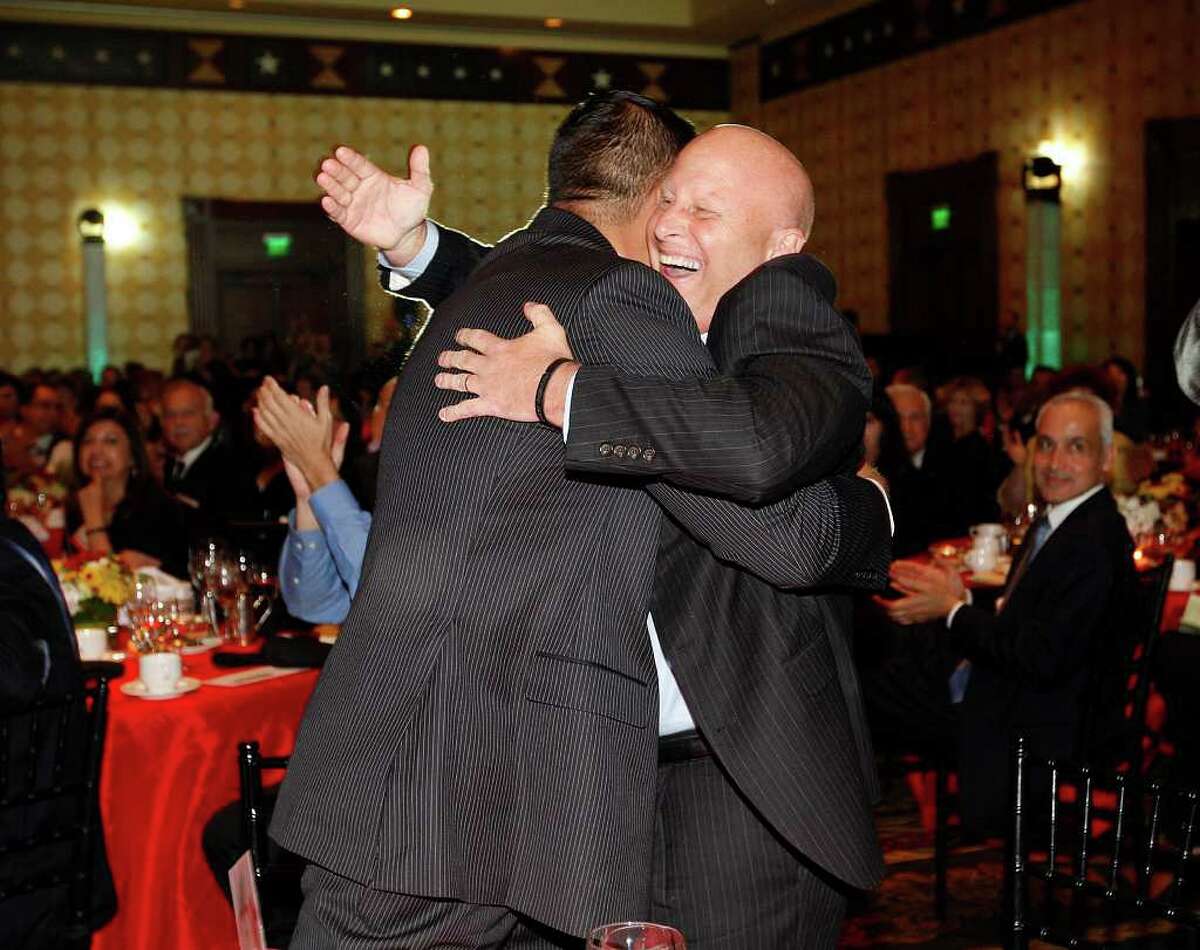 Harlandale ISD Superintendent Robert Jaklich, right, hugs Board President Anthony Alcoser after the district won the Large District category of the 10th annual H-E-B Excellence in Education Awards in Austin on  Sunday. JERRY LARA/glara@express-news.net