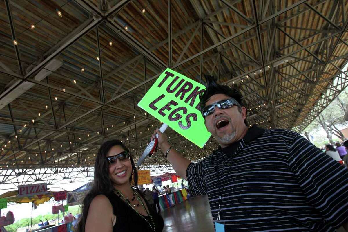 Raymond Reyna (right) advertises turkey legs and chicken on a stick (other side of sign) at Rosedale Park Sunday May 15, 2011 during the last day of the Tejano Conjunto Festival. Keeping Reyna company is Leianni de Leon (left). The festival began last Thursday. JOHN DAVENPORT/jdavenport@express-news.net
