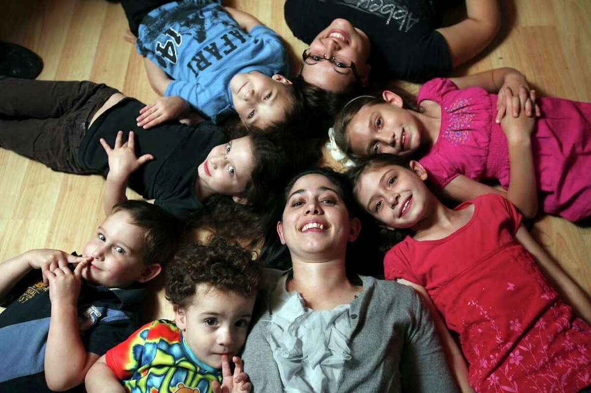 Melissa Anderson (bottom center) poses with her children, John, 2 (clockwise from bottom); Timothy, 3; Arabella, 5; Samuel, 6; Kayli, 20, a sister she adopted; Elizabeth, 9; and Magdalyne, 8. (PHOTO BY EDWARD A. ORNELAS/eaornelas@express-news.net)