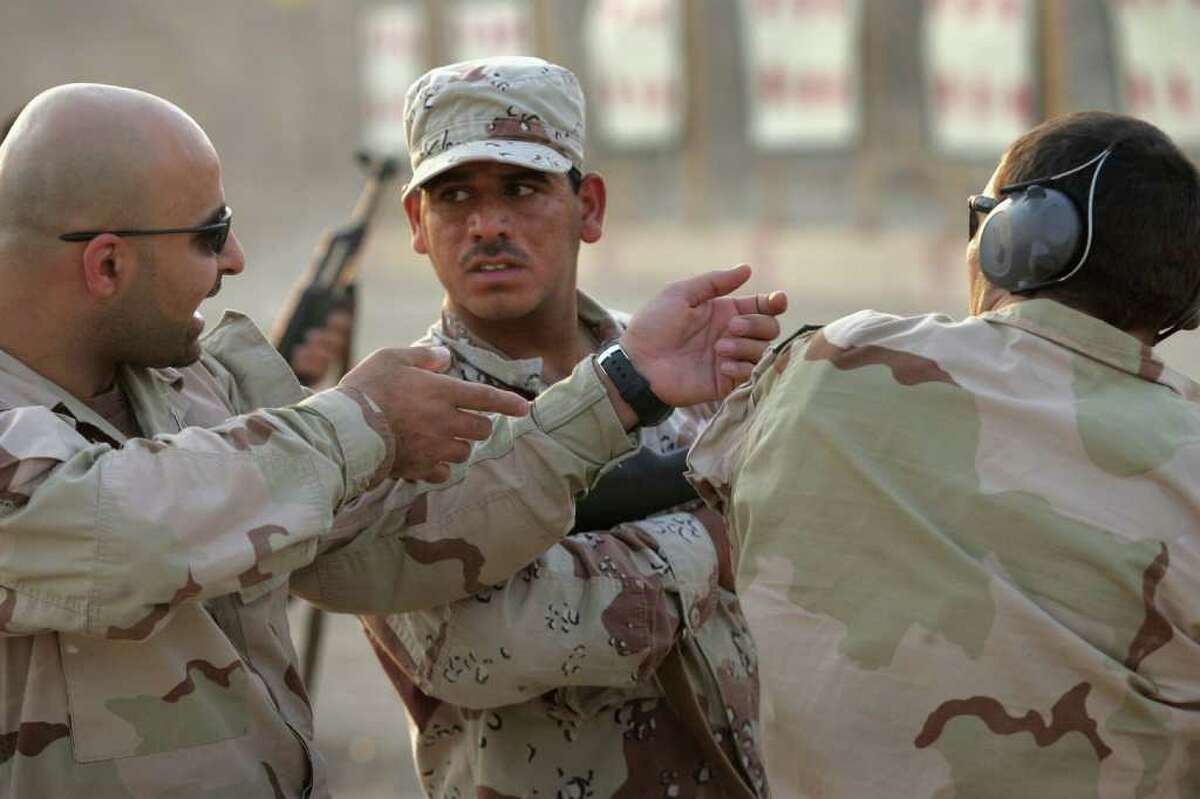 FALLUJAH, IRAQ - JULY 26: A U.S. Navy SEAL, (R), explains proper weapons handling through a translator to an Iraqi army scout during training July 26, 2007 in Fallujah, Iraq. The SEALS are training Iraqi forces on advanced combat techniques as part of the American effort to build up the Iraqi military. (Photo by John Moore/Getty Images)