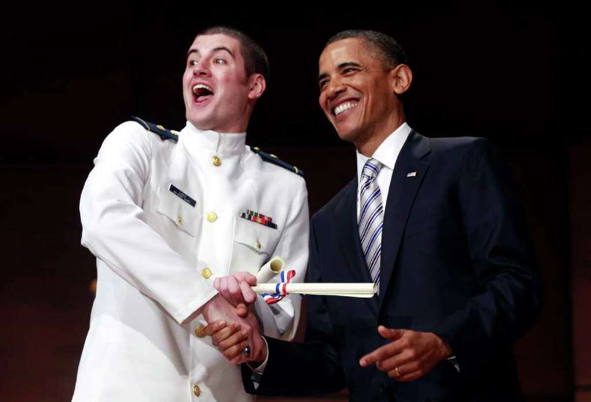 Ensign Jonathan Lang celebrates with President Barack Obama at the U.S. Coast Guard Academy graduation in New London, Conn., Wednesday, May 18, 2011. (AP Photo/Charles Dharapak)