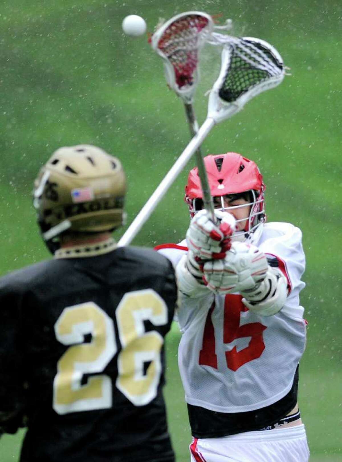 Joseph Riehl of Trumbull High School, left, # 26, passes while being defended by Kyle Foote, # 15 of Greenwich High School, during boys high school lacrosse game between Greenwich High School and Trumbull High School at Greenwich High School, Wednesday afternoon, May 18, 2011.