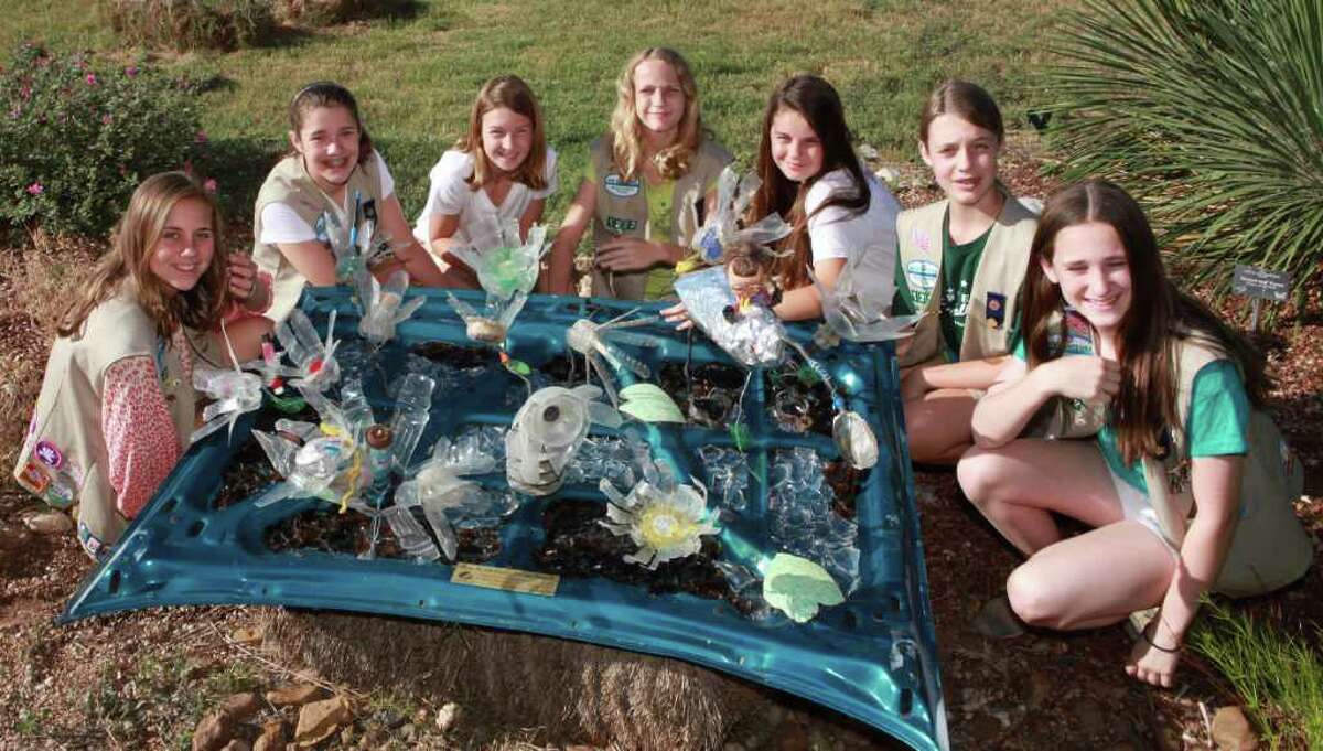 Girl Scout Silver Award-winners from Troop 1222 show off part of their community service project, an art collage crafted with trash found at Mitchell Lake. From left are Jane Emma Barnett, Katie White, Hannah Shaeffer, Addison Nelson, Hannah Ortega, Camilla Kampmann and Sarah Berton.