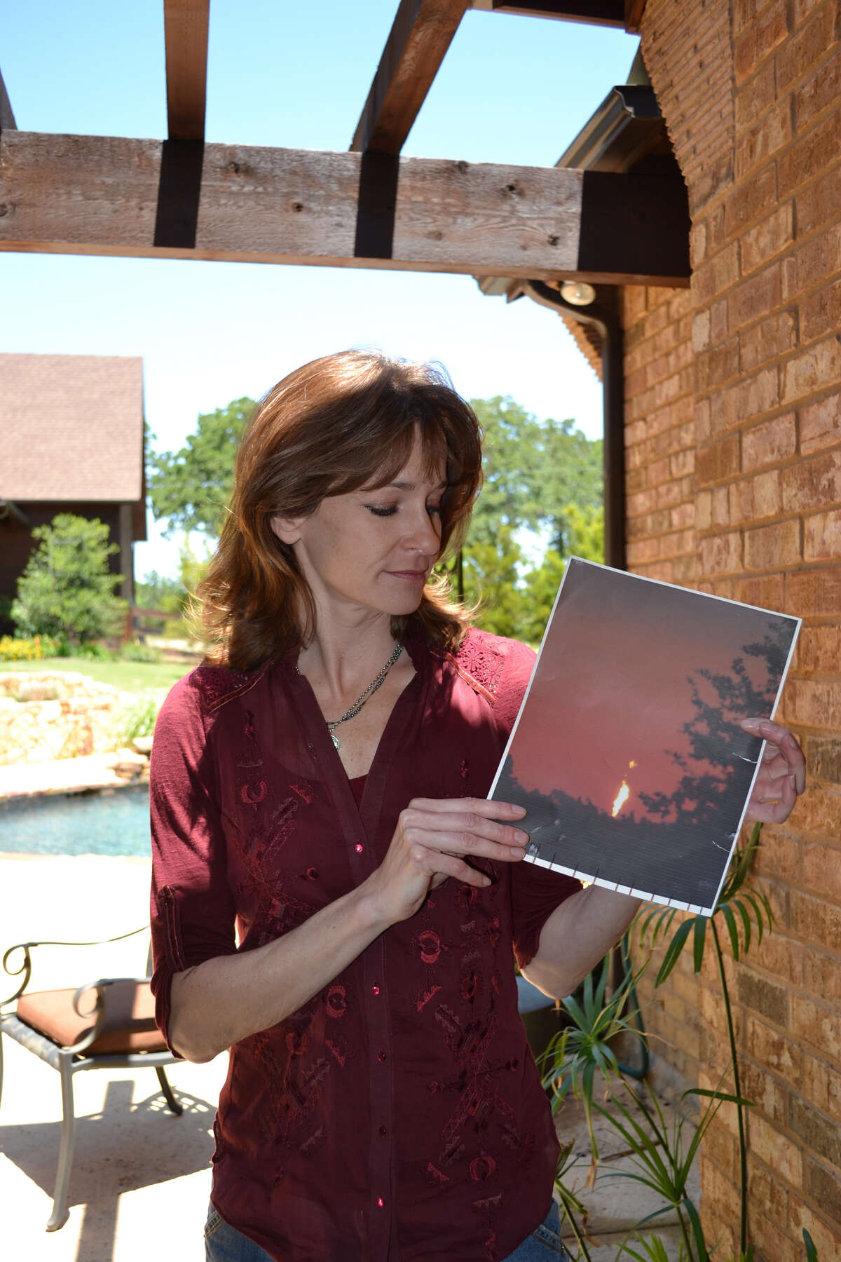 Kelly Grant holds a photograph of a natural-gas flare at a well near her home in Argyle. She took the photo from her daughter's upstairs bedroom.