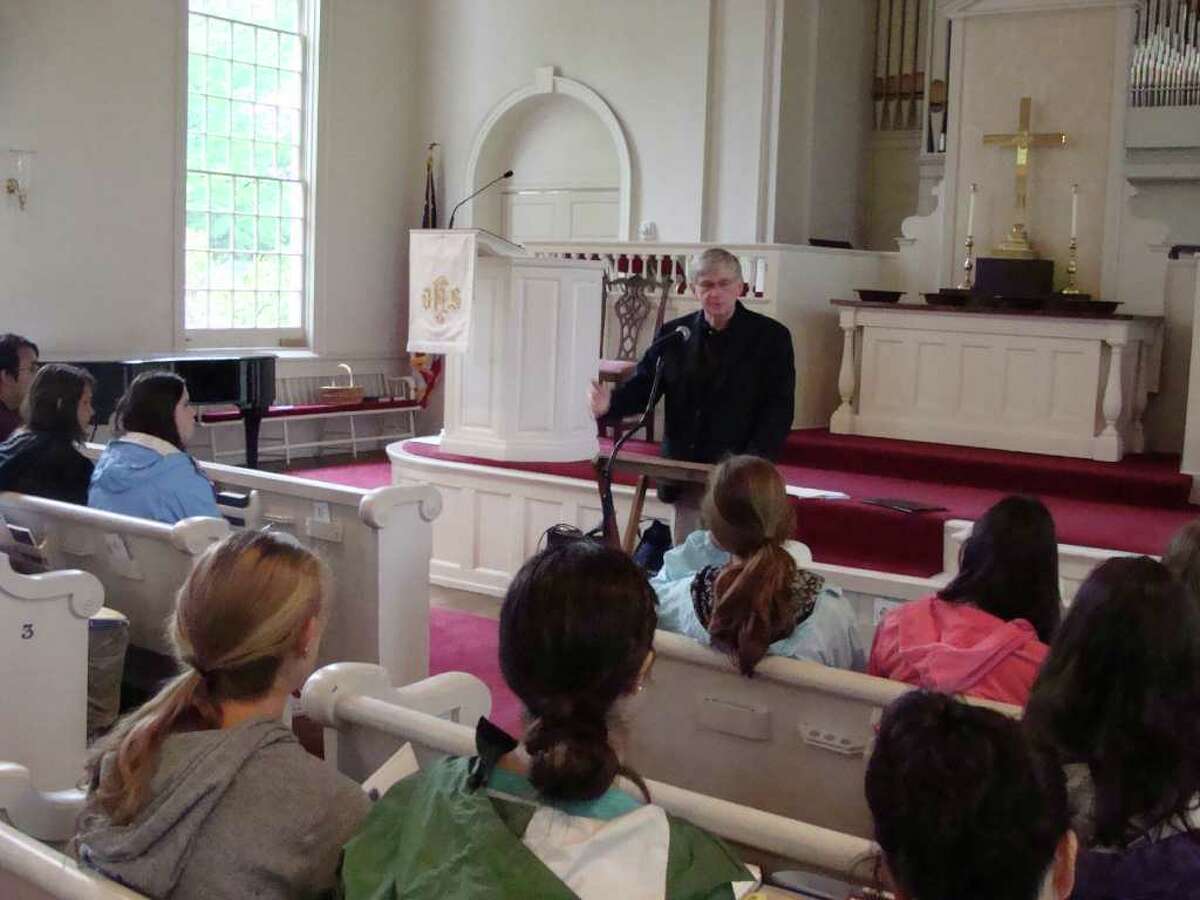 Rev. David Rowe, pastor of Greenfield Hill Congregational Church, talks about Protestantism with students from Fairfield Warde High School on Tuesday. Rowe's church was one of four houses of worship students visited as part of a history class.