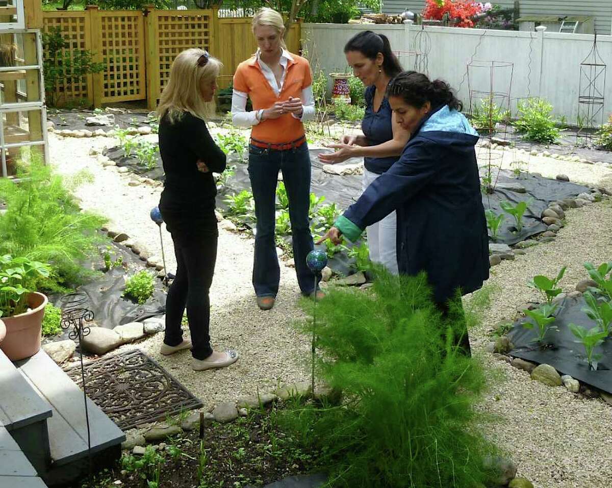 Heather Carey, second from right, leads participants in her "Kitchen Garden Workshop" on a tour of her home-based vegetable and herb garden.
