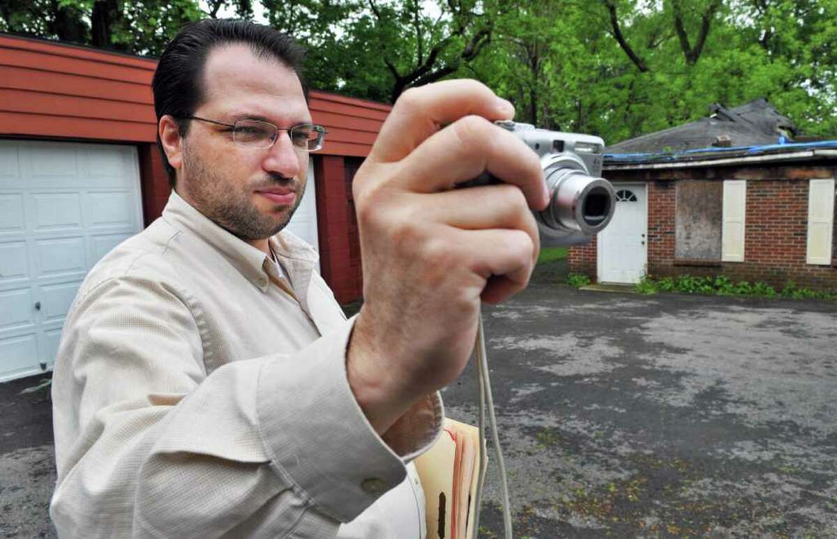 Real estate appraiser David Fontana photographs a multi-unit dwelling in Schenectady Friday morning May 20, 2011. (John Carl D'Annibale / Times Union)