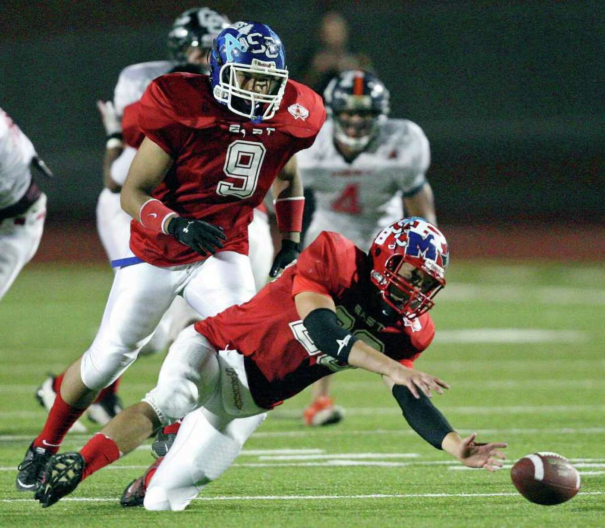 East team's Drake Cannon grabs for a fumble as teammate East team's Vincent Yates Jr. move in during second half action against the West team in the 33rd annual Pizza Hut High School All-Star Football Game held Saturday May 21, 2011 at Heroes Stadium. The East team won 15-7.