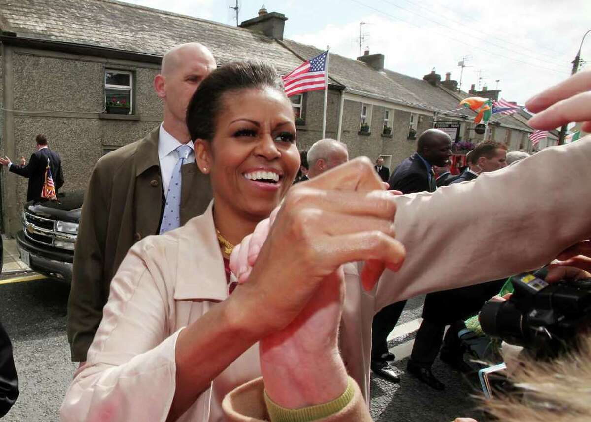 MONEYGALL, IRELAND - MAY 23: First Lady Michelle Obama greets the locals in her husbands ancestral home of Moneygall on May 23, 2011 in Moneygall, Ireland. U.S. President Obama is visiting Ireland for one day at the start of a week long tour of Europe. He will meet with distant relatives in Moneygall and speak at a rally in central Dublin after a concert. (Photo by Irish Government - Pool/Getty Images)