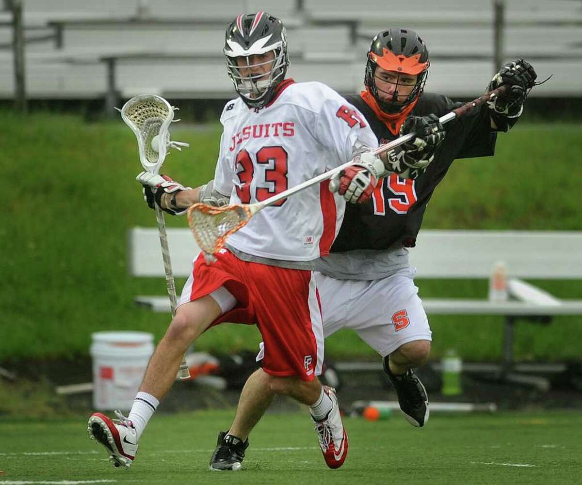 Fairfield Prep's Matt Mendicino, left, carries the ball while being defended by Shelton's Brian Antunes during the Jesuits 16-1 victory in the opening round of the SCC playoffs at Fairfield University's Alumni Field in Fairfield on Monday, May 23, 2011.