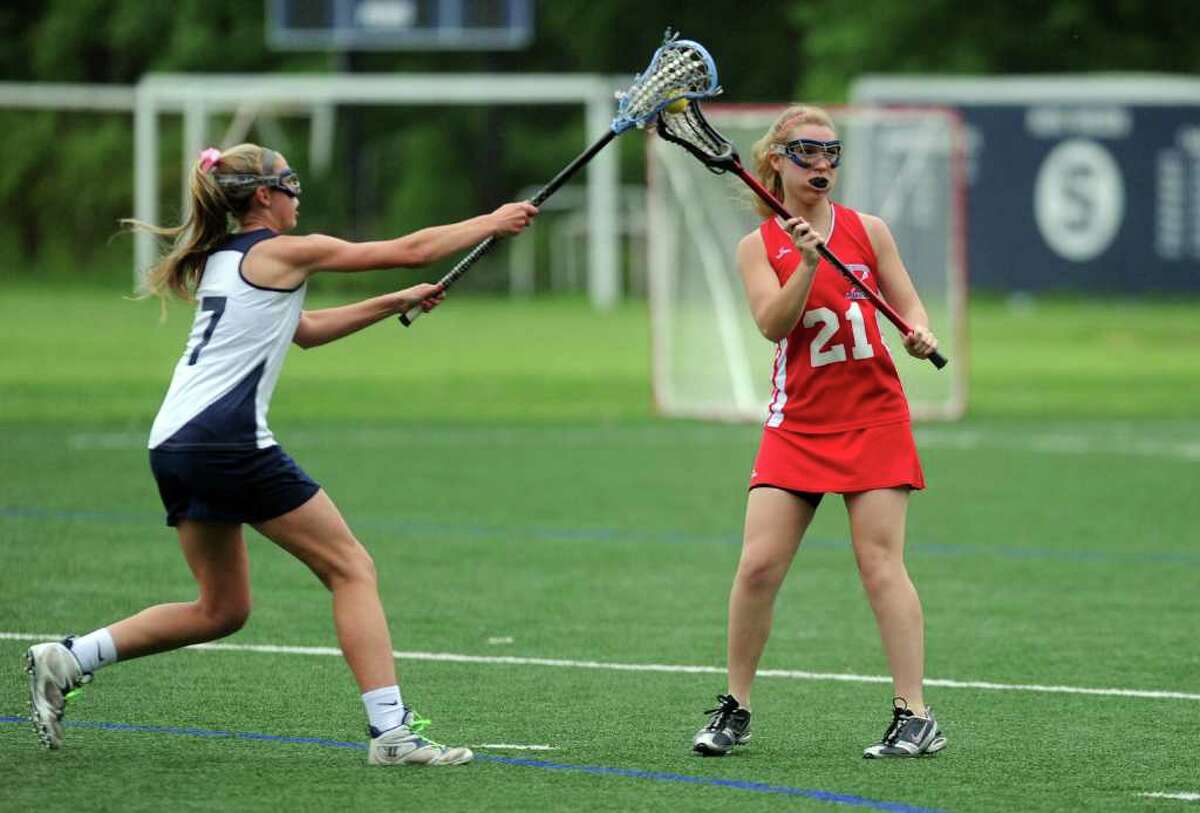 Staples High School lacrosse player Maeve Flaherty, left, reaches to block a shot last week. Flaherty was one of nine lacrosse players from six different schools whose eligibility was reinstated by the Connecticut Interscholastic Athletic Conference Tuesday morning, 24 hours after they were sanctioned for violating state rules.