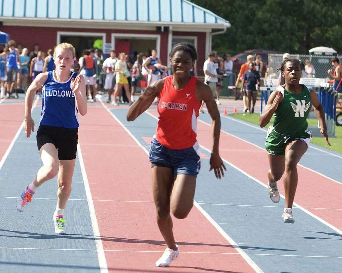 Brien McMahon's Shelly Lindo, center, wins the 100 meters at the FCIAC Track and Field Championships Tuesday at Danbury High School.