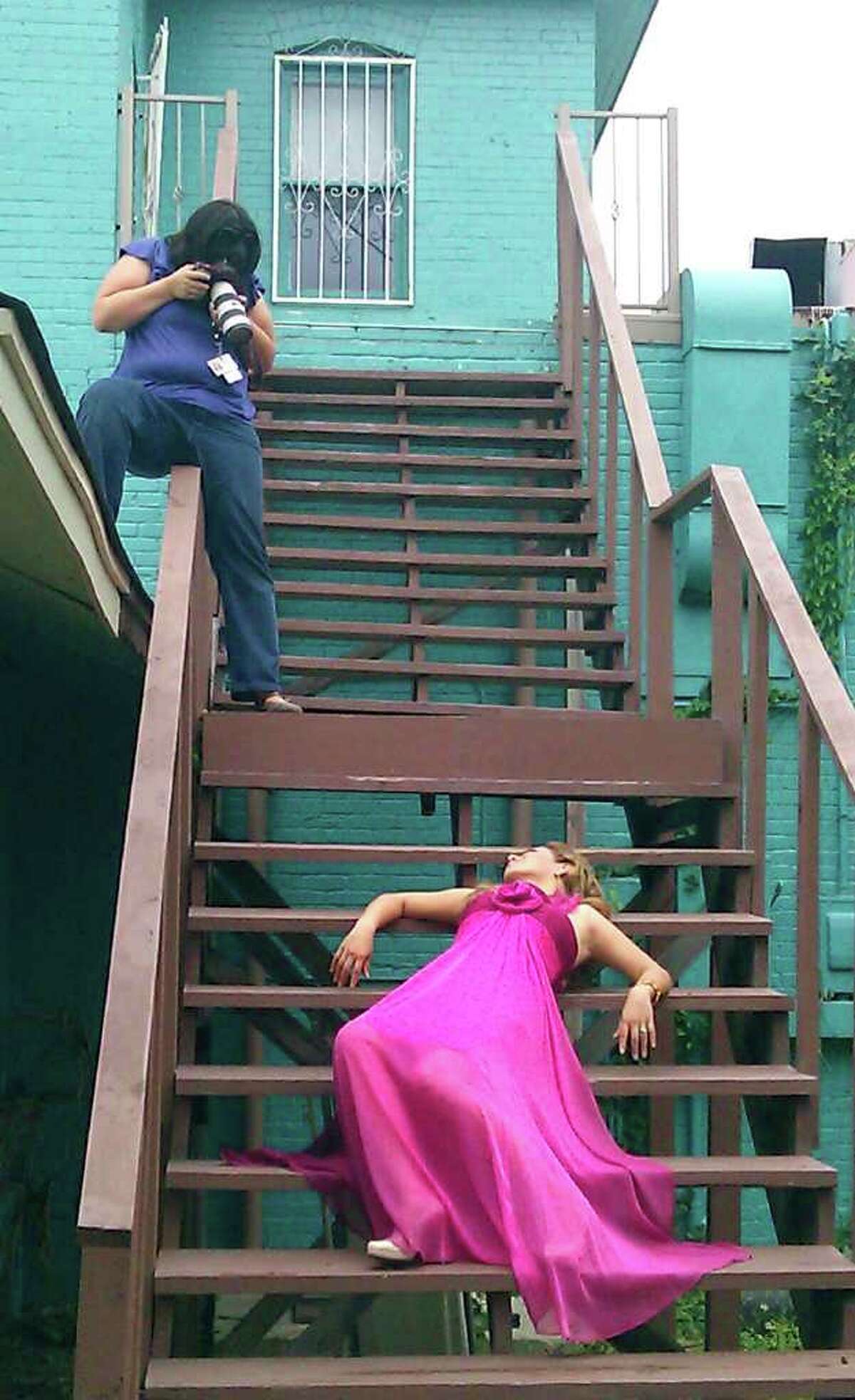 Staff photographer Helen L. Montoya lines up a photograph on the rear stairs of dance studio Calle Ocho. Conexion's 2011 Hottest Latina winner Luzelena Ortiz-Lopez models spring fashions from Macy's North Star. Photo by Tricia Schwennesen