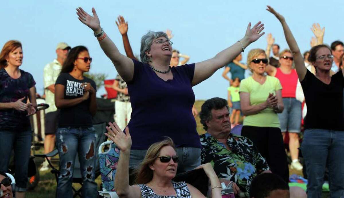 Francesca Watson (center) raises her arms in praise during a service held Sunday May 22, 2011 at the site of the former Verizon Wireless Amphitheater on Lookout Road. The River City Community Church will be moving from its location on Jones Maltsberger to the site of the former Verizon Wireless Amphitheater. JOHN DAVENPORT/jdavenport@express-news.net