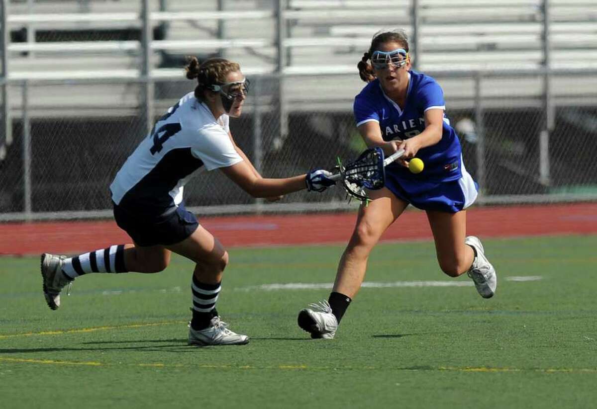 Wilton's Casey Bearsall and Darien's Jenna Fritts reach for the ball during Friday's FCIAC final at Brien McMahon High School in Norwalk on May 28, 2011.