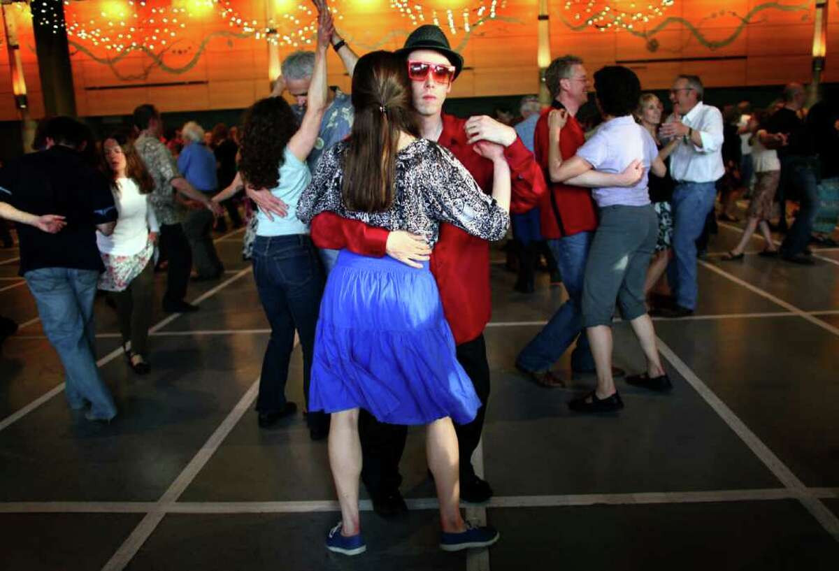 Kevin Buster dances with Michelle Mead in Fischer Pavilion during the Northwest Folklife Festival on Saturday, May 28, 2011 at the Seattle Center. The annual Memorial Day weekend festival is celebrating its 40th anniversary. It continues through Monday.