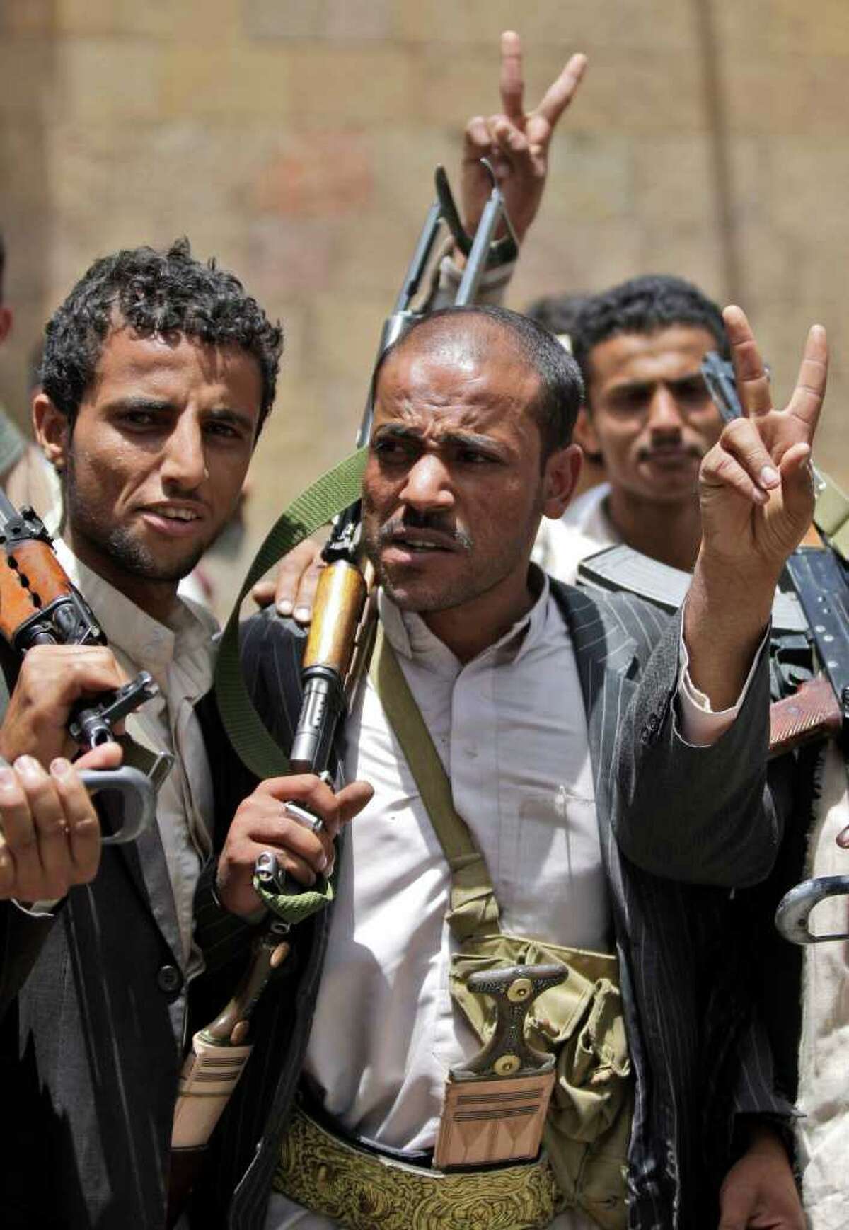 Armed Yemeni tribesmen, flash the victory sign while gathering outside the Ministry of Local Administration in Sanaa, Yemen, Sunday, May 29 ,2011. Yemen's embattled president and the country's most powerful tribal leader have agreed to end five days of gun battles that killed scores of people and pushed the country's political crisis closer to civil war. (AP Photo/Hani Mohammed)