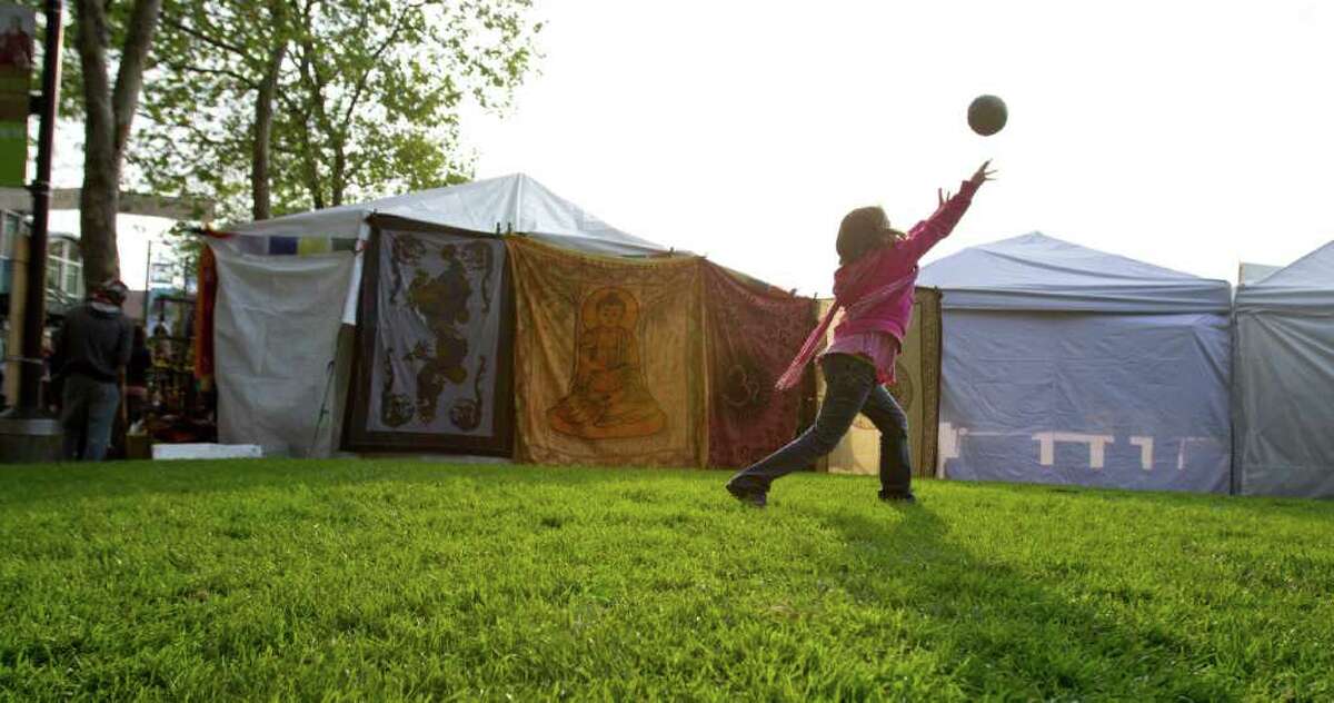 This 8-year-old enjoys a game of catch with her uncle at the Northwest Folklife Festival on Monday.