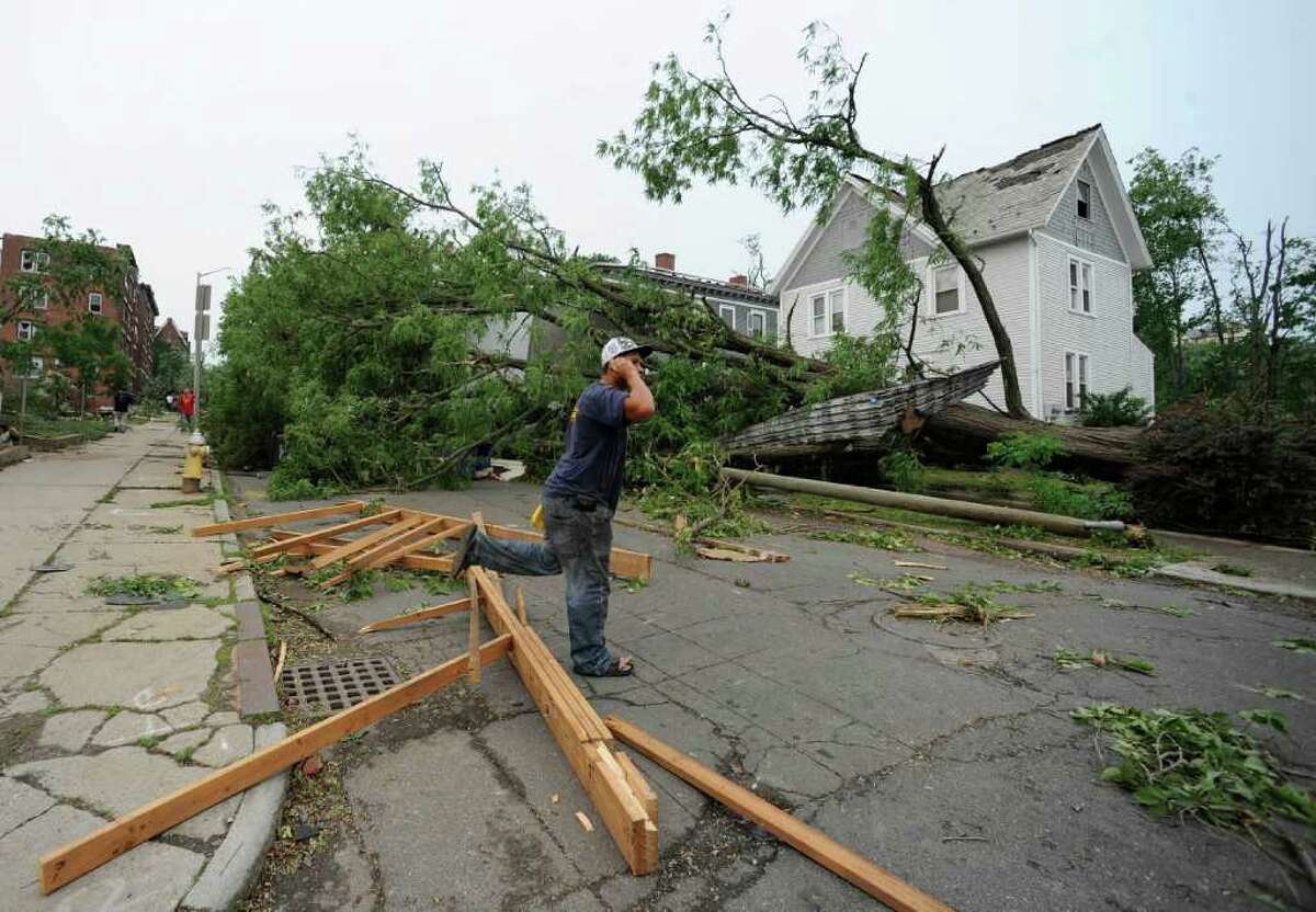 A man talks on his phone near storm damage after a reported tornado struck downtown Springfield, Mass., Wednesday, June 1, 2011. An apparent tornado struck downtown Springfield, one of Massachusetts' largest cities, scattering debris, toppling trees, and frightening workers and residents. (AP Photo/Jessica Hill)