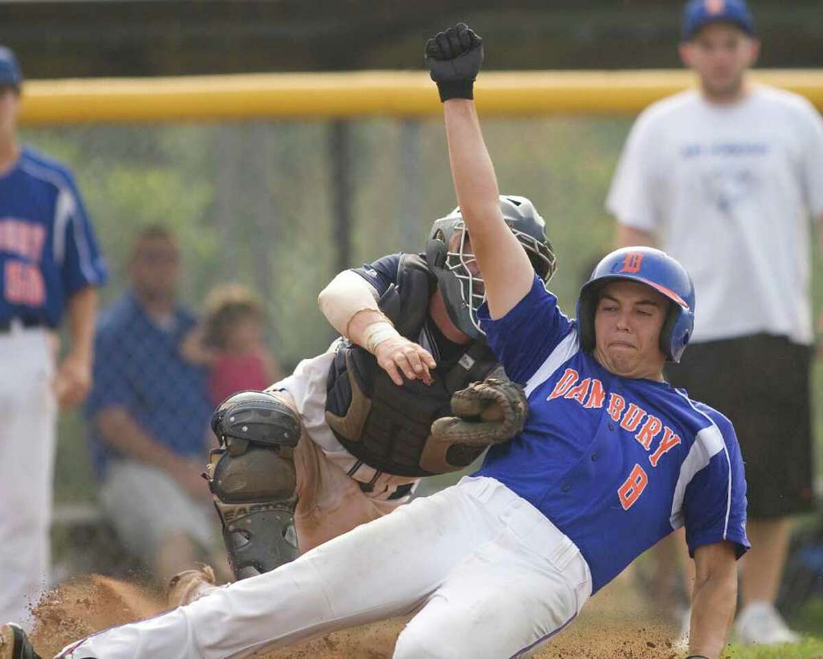 Danbury's B.J. Nimer slides home safely under the high tag of Staples catcher Mike McGowan during the Hatters' 6-4 win in the second round of the Class LL state tournament Wednesday at Danbury High School.