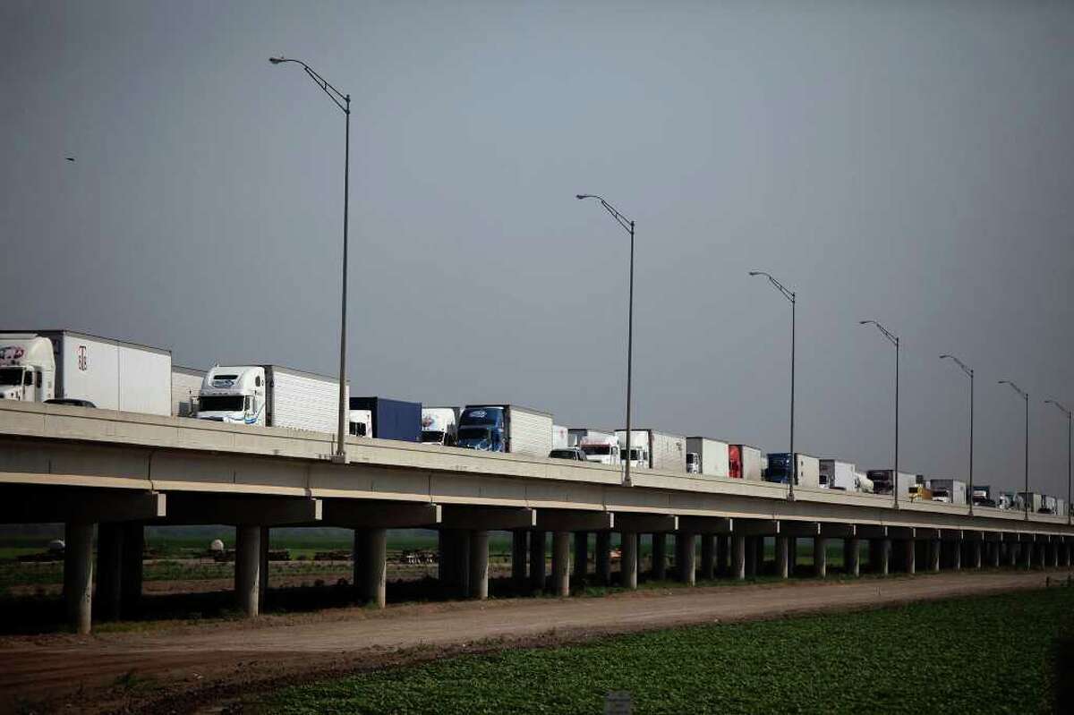 Trucks wait on the Pharr-Reynosa International Bridge to enter the U.S. In Pharr, customs officials inspect the cargo.