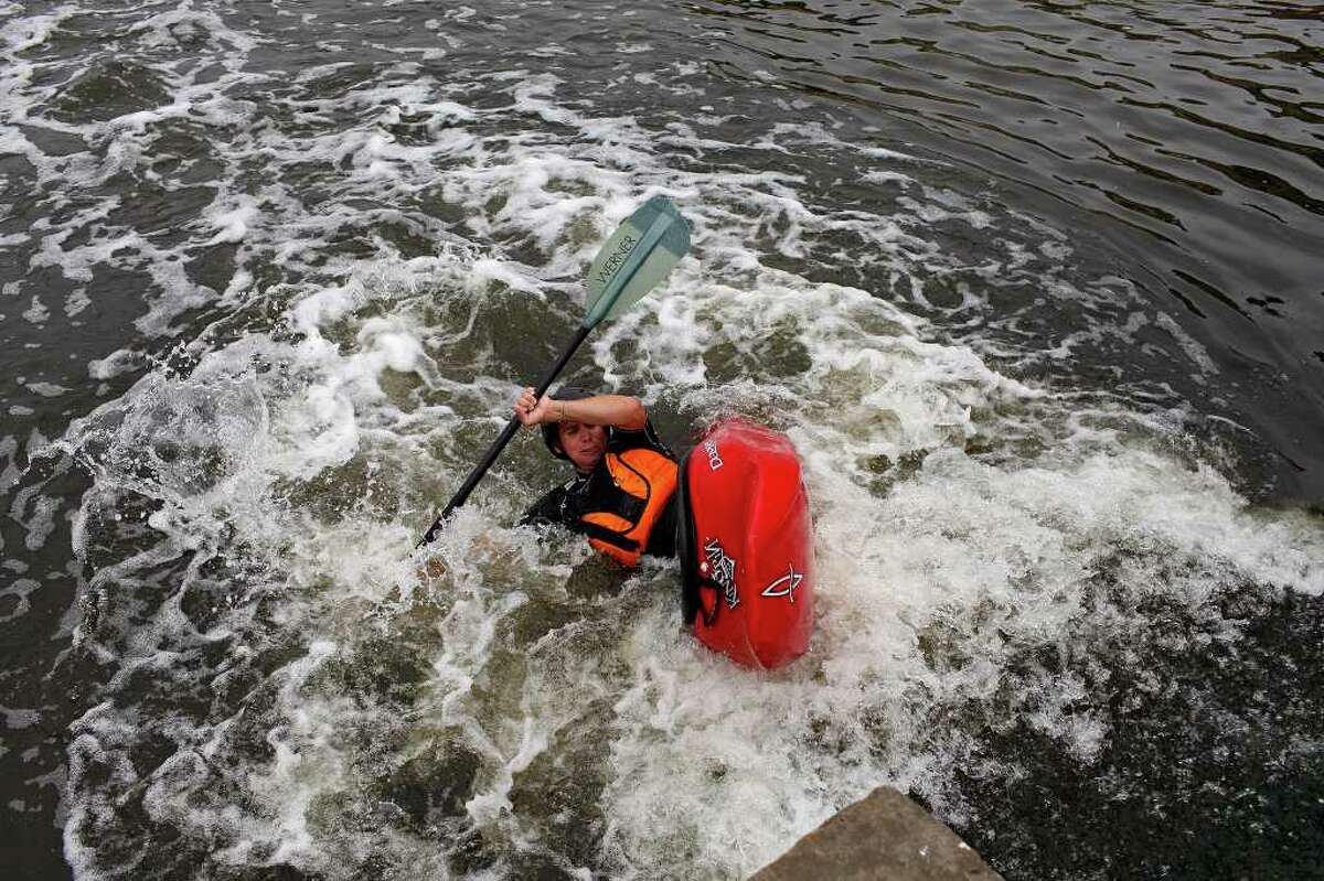 Craig Norris plays in the currents created by a chute on a small dam on the Mission Reach portion of the San Antonio River as he tries to find out if the river is accessible by canoe or kayak on Saturday, May 21, 2011. The San Antonio River Authority organized the trial run.