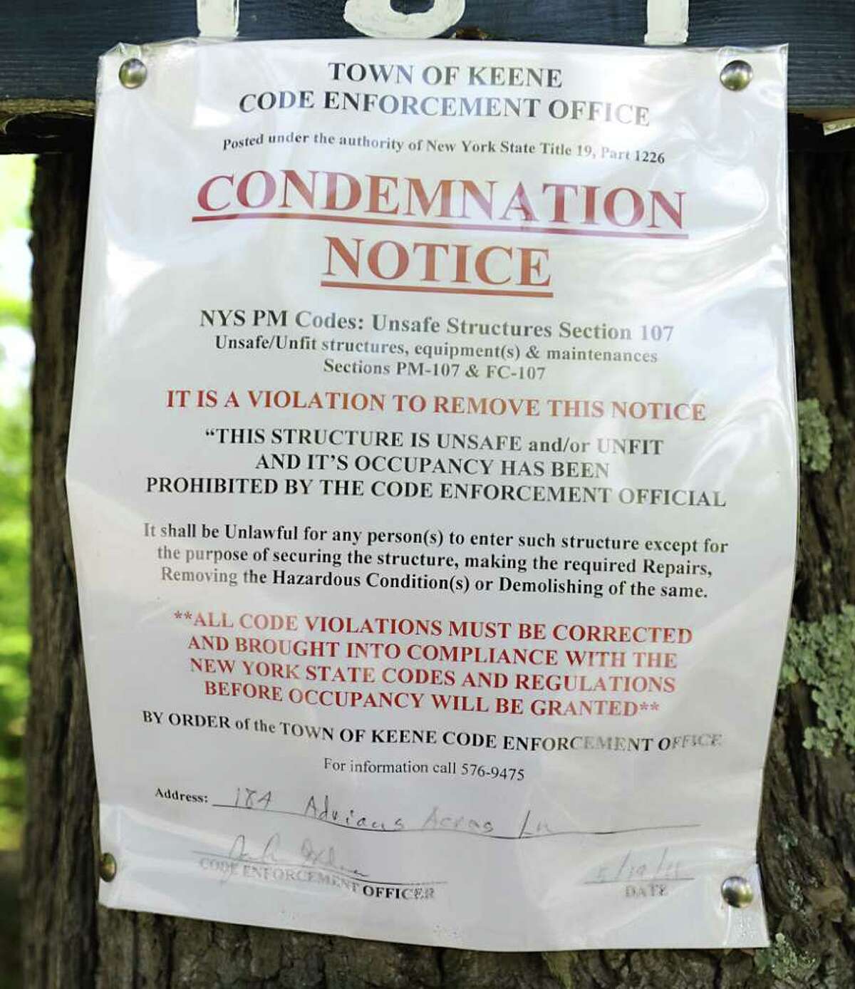 A condemnation notice is nailed to a tree at the beginning of the Machold's driveway in Keene Valley, N.Y. Tuesday May 31, 2011. (Lori Van Buren / Times Union)