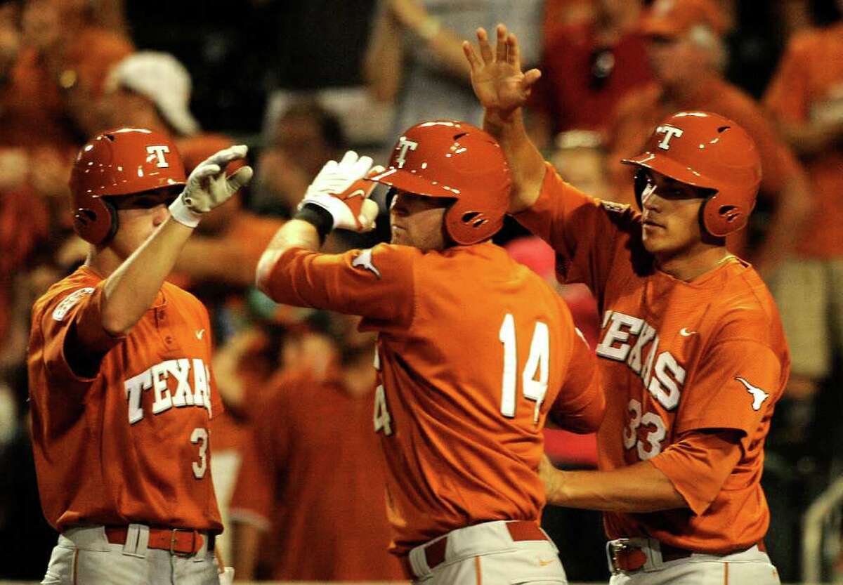 Kevin Lusson (14) is met by teammates Paul Montalbano, left, and Jonathan Walsh after hitting a ninth-inning home run during NCAA Baseball Austin Regional action against Kent State on Saturday, June 4, 2011. BILLY CALZADA / gcalzada@express-news.net